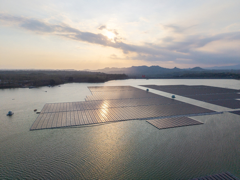 Aerial view of the floating solar farm on the Sutami Dam reservoir at sunset with mountains in the background in Kecamatan Sumberpucung Jawa Timur Indonesia. Aerial view of the floating solar farm on the Sutami Dam reservoir at sunset with mountains in the background in Kecamatan Sumberpucung Jawa Timur Indonesia.
