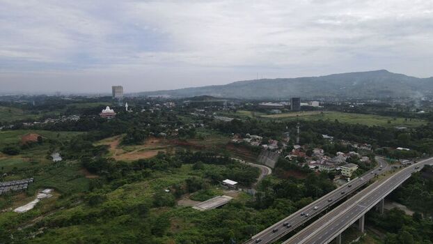 Aerial view of Sentul area featuring a highway bridge crossing over lush green hills and residential neighborhoods in Babakan Madang West Java Indonesia. Aerial view of Sentul area featuring a highway bridge crossing over lush green hills and residential neighborhoods in Babakan Madang West Java Indonesia.