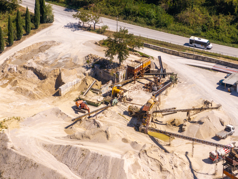 Aerial view of an industrial quarry site with heavy machinery conveyor belts piles of sand and gravel and trucks in Ortezzano Marche Italy. Aerial view of an industrial quarry site with heavy machinery conveyor belts piles of sand and gravel and trucks in Ortezzano Marche Italy.