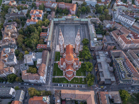 Aerial view of Szeged Cathedral with its distinctive twin towers and red tiled roof situated in the expansive Dom ter surrounded by historic urban architecture in Szeged Hungary. Aerial view of Szeged Cathedral with its distinctive twin towers and red tiled roof situated in the expansive Dom ter surrounded by historic urban architecture in Szeged Hungary.