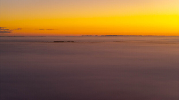 Aerial view of Stonehenge emerging from a thick layer of morning fog at sunrise in Salisbury England United Kingdom. Aerial view of Stonehenge emerging from a thick layer of morning fog at sunrise in Salisbury England United Kingdom.