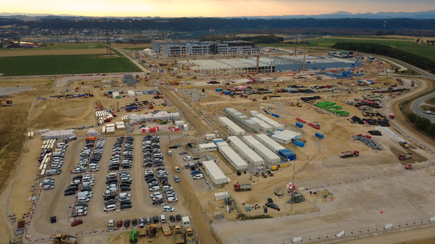Aerial view of a data center construction site with heavy machinery office containers and a parking lot filled with vehicles during early morning in Kronstorf Upper Austria Austria.