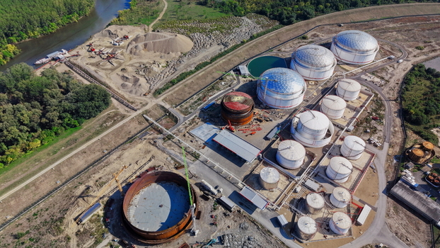 Aerial view of fuel tanks at an industrial facility with construction equipment and a river nearby in Kovin Vojvodina Serbia. Aerial view of fuel tanks at an industrial facility with construction equipment and a river nearby in Kovin Vojvodina Serbia.