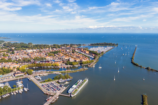 Aerial view of the historic harbor and town with numerous boats docked vessels and traditional Dutch architecture along the waterfront in Enkhuizen North Holland Netherlands. Aerial view of the historic harbor and town with numerous boats docked vessels and traditional Dutch architecture along the waterfront in Enkhuizen North Holland Netherlands.