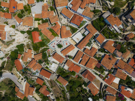 Aerial view of traditional orange tiled rooftops and narrow streets surrounding a small central square in Dhermi Vlore County Albania. Aerial view of traditional orange tiled rooftops and narrow streets surrounding a small central square in Dhermi Vlore County Albania.