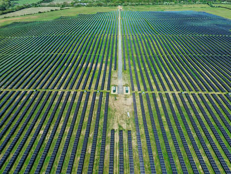 Aerial view of a large solar farm with rows of photovoltaic panels installed in a green field under bright daylight Little Irchester England United Kingdom. Aerial view of a large solar farm with rows of photovoltaic panels installed in a green field under bright daylight Little Irchester England United Kingdom.