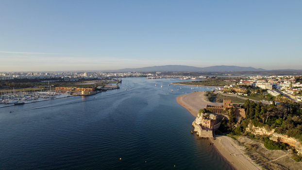 Aerial view of the historic Castelo de Sao Joao do Arade overlooking the Arade River marina and sandy beach in the coastal town of Ferragudo Faro District Portugal.