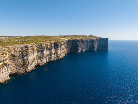 Aerial view of the rugged limestone cliffs and deep blue waters of the Mediterranean Sea Gozo Region Malta. Aerial view of the rugged limestone cliffs and deep blue waters of the Mediterranean Sea Gozo Region Malta.