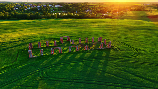 Aerial view of ancient stone ruins standing in a vibrant green field during golden hour in Latvia. Aerial view of ancient stone ruins standing in a vibrant green field during golden hour in Latvia.