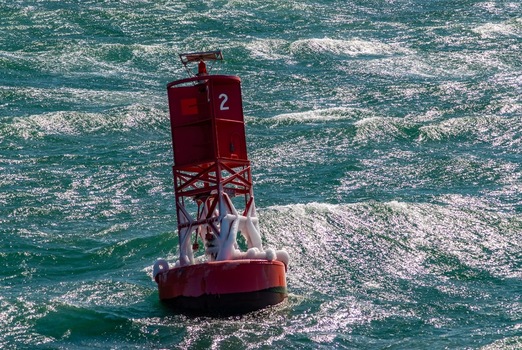 View of a red navigation buoy floating in the choppy green waters off Martha s Vineyard Edgartown Massachusetts United States.