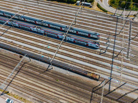 Aerial view of Daniken train station with multiple parallel tracks modern passenger trains and a freight train in Daniken Solothurn Switzerland.