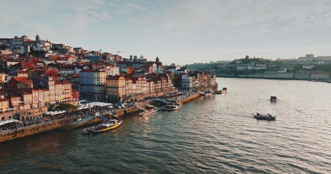 Aerial view of the historic Ribeira district along the Douro River with colorful traditional buildings and boats in Porto Portugal. Aerial view of the historic Ribeira district along the Douro River with colorful traditional buildings and boats in Porto Portugal.