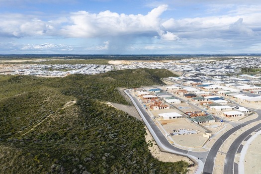 Aerial view of a new residential development with modern houses under construction paved roads and surrounding natural coastal vegetation in Perth Western Australia Australia. Aerial view of a new residential development with modern houses under construction paved roads and surrounding natural coastal vegetation in Perth Western Australia Australia.