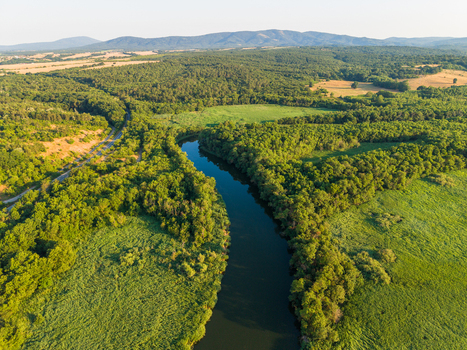 Aerial view of the Karaagach river winding through lush green forests and meadows in the countryside of Kiten Burgas Bulgaria. Aerial view of the Karaagach river winding through lush green forests and meadows in the countryside of Kiten Burgas Bulgaria.