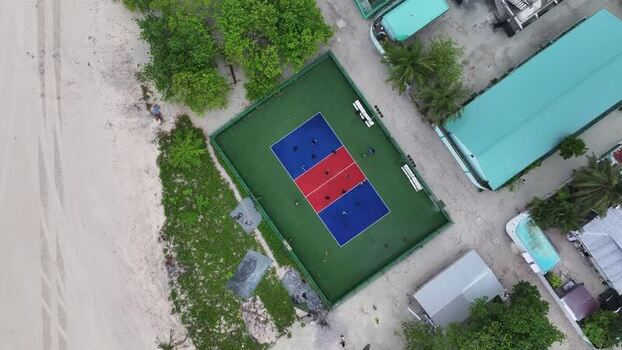 Aerial view of people playing on a colorful sports court Maldives. Aerial view of people playing on a colorful sports court Maldives.