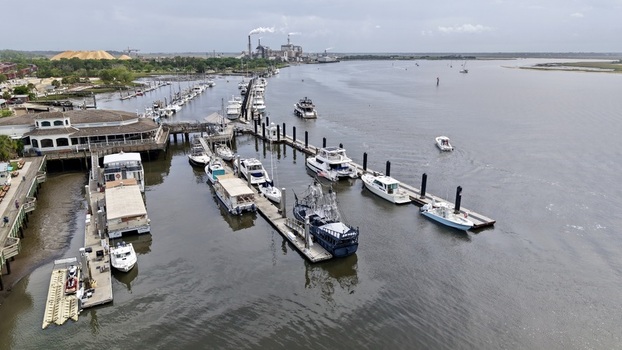Aerial view of boats docked along the marina with a backdrop of industrial structures and the river s tranquil flow Fernandina Beach Florida United States. Aerial view of boats docked along the marina with a backdrop of industrial structures and the river s tranquil flow Fernandina Beach Florida United States.