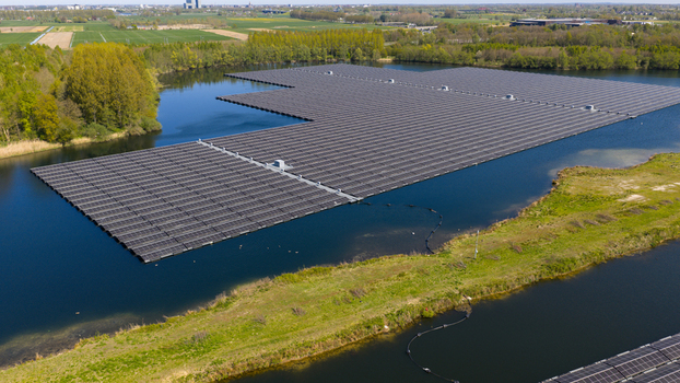 Aerial view of a large floating solar farm on a calm lake surrounded by lush green trees and fields Zwolle Overijssel Netherlands. Aerial view of a large floating solar farm on a calm lake surrounded by lush green trees and fields Zwolle Overijssel Netherlands.