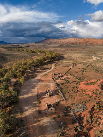 Aerial view of the historic stone ruins of Kanyaka Station along a winding dirt road in the dry outback landscape Flinders Ranges South Australia Australia. Aerial view of the historic stone ruins of Kanyaka Station along a winding dirt road in the dry outback landscape Flinders Ranges South Australia Australia.