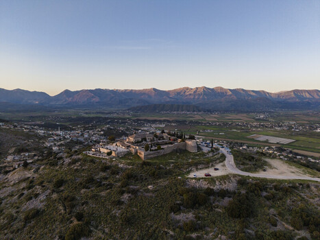 Aerial view of Lekuresi Castle situated on a hilltop overlooking the town of Saranda with surrounding mountains green landscape and clear sky in Saranda Vlore County Albania. Aerial view of Lekuresi Castle situated on a hilltop overlooking the town of Saranda with surrounding mountains green landscape and clear sky in Saranda Vlore County Albania.