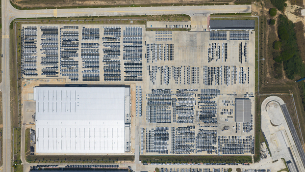 Aerial view of the BYD Auto Thailand Co. Ltd. factory with a large warehouse and thousands of parked vehicles in Phananikhom Rayong Thailand.