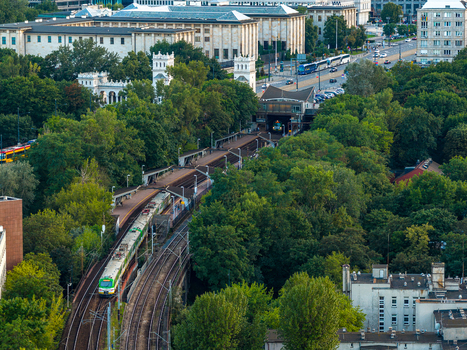 Warsaw Poland 29 July 2025 Aerial view of the Powisle railway station tracks surrounded by lush green trees and urban architecture in the city center. Warsaw Poland 29 July 2025 Aerial view of the Powisle railway station tracks surrounded by lush green trees and urban architecture in the city center.
