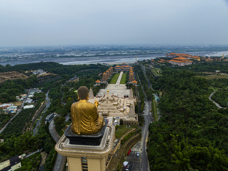 Aerial view of the golden Buddha statue overlooking the expansive Fo Guang Shan Buddha Museum complex with its pagodas and walkways surrounded by lush greenery in Dashu District Kaohsiung Taiwan. Aerial view of the golden Buddha statue overlooking the expansive Fo Guang Shan Buddha Museum complex with its pagodas and walkways surrounded by lush greenery in Dashu District Kaohsiung Taiwan.