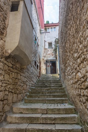 View of a narrow stone staircase winding through the historic alleyways of the old town in Rovinj Istria County Croatia. View of a narrow stone staircase winding through the historic alleyways of the old town in Rovinj Istria County Croatia.