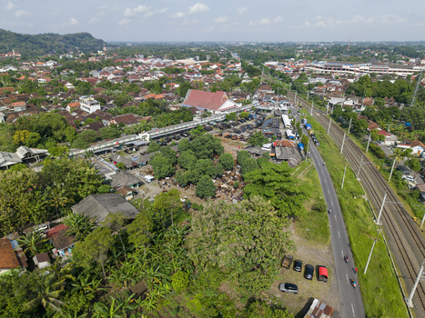 Aerial view of the Animal Market Prambanan with livestock under trees near railway tracks and urban rooftops in Kecamatan Prambanan Jawa Tengah Indonesia. Aerial view of the Animal Market Prambanan with livestock under trees near railway tracks and urban rooftops in Kecamatan Prambanan Jawa Tengah Indonesia.
