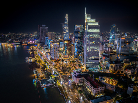 Aerial view of Ho Chi Minh City skyline at night featuring the Bitexco Financial Tower illuminated skyscrapers and the Saigon River Vietnam. Aerial view of Ho Chi Minh City skyline at night featuring the Bitexco Financial Tower illuminated skyscrapers and the Saigon River Vietnam.
