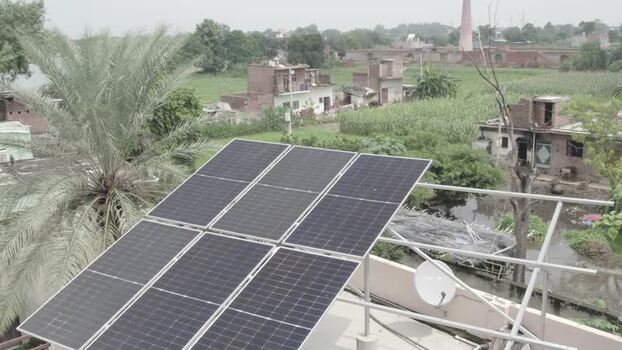 Aerial view of solar panels on a rural rooftop in India.