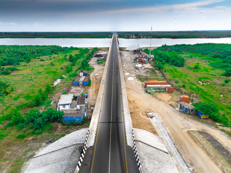 Aerial view of the bridge on Bonny Island surrounded by lush greenery shipping containers and river water in Bonny Town Rivers Nigeria. Aerial view of the bridge on Bonny Island surrounded by lush greenery shipping containers and river water in Bonny Town Rivers Nigeria.