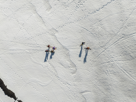 Aerial view of skiers trekking across the snow covered south slope of Mount Etna with long shadows and tracks in Nicolosi Sicilia Italy. Aerial view of skiers trekking across the snow covered south slope of Mount Etna with long shadows and tracks in Nicolosi Sicilia Italy.