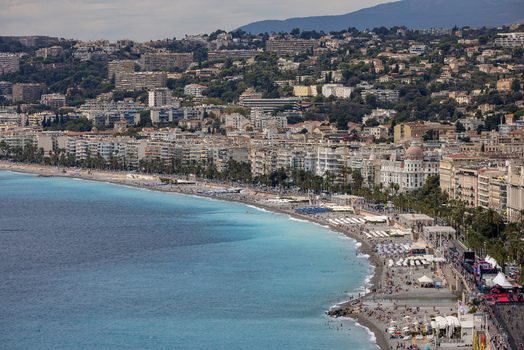 Aerial view of the Promenade des Anglais and the turquoise Mediterranean Sea coastline with urban buildings and crowded beaches in Nice Provence Alpes Cote d Azur France. Aerial view of the Promenade des Anglais and the turquoise Mediterranean Sea coastline with urban buildings and crowded beaches in Nice Provence Alpes Cote d Azur France.