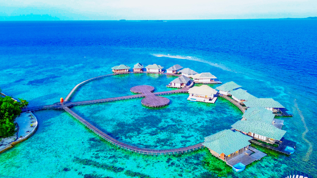 Aerial view of Karimun Jawa resort with overwater bungalows connected by wooden walkways over turquoise water in Jepara Central Java Indonesia. Aerial view of Karimun Jawa resort with overwater bungalows connected by wooden walkways over turquoise water in Jepara Central Java Indonesia.