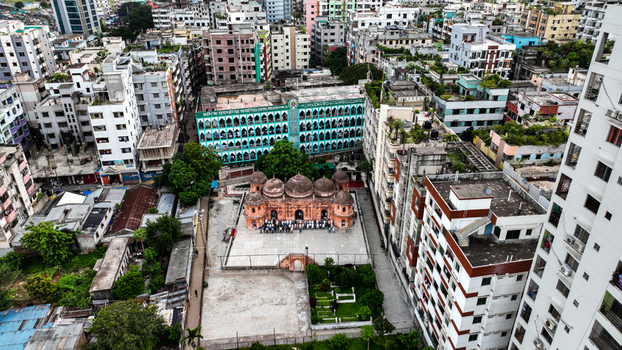 Aerial view of the historic Khan Mohammad Mridha Mosque surrounded by dense urban residential buildings and rooftops in Dhaka Dhaka Division Bangladesh. Aerial view of the historic Khan Mohammad Mridha Mosque surrounded by dense urban residential buildings and rooftops in Dhaka Dhaka Division Bangladesh.