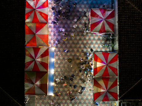Aerial view of GOR Gelarsena Klaten Night Market with red and white striped tents and people walking on patterned tiles at night Kecamatan Klaten Utara Jawa Tengah Indonesia. Aerial view of GOR Gelarsena Klaten Night Market with red and white striped tents and people walking on patterned tiles at night Kecamatan Klaten Utara Jawa Tengah Indonesia.