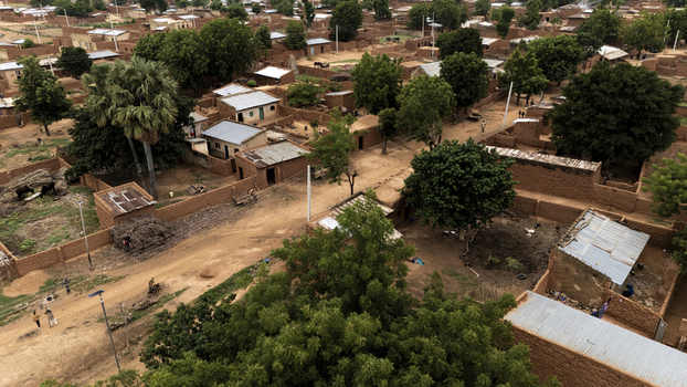 Aerial view of a rural village with traditional mud brick houses dirt paths and lush trees in Dambatta Kano Nigeria. Aerial view of a rural village with traditional mud brick houses dirt paths and lush trees in Dambatta Kano Nigeria.