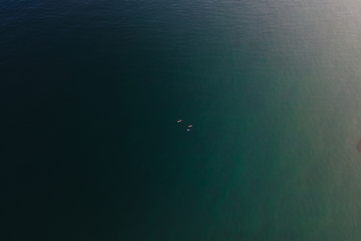 Aerial view of surfers floating on the calm turquoise waters of the Mediterranean Sea in Sitges Catalonia Spain. Aerial view of surfers floating on the calm turquoise waters of the Mediterranean Sea in Sitges Catalonia Spain.