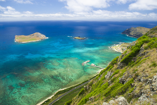 View of Waimanalo Bay overlooking the turquoise coastal waters offshore islands and rugged cliffs in Waimanalo Hawaii United States. View of Waimanalo Bay overlooking the turquoise coastal waters offshore islands and rugged cliffs in Waimanalo Hawaii United States.
