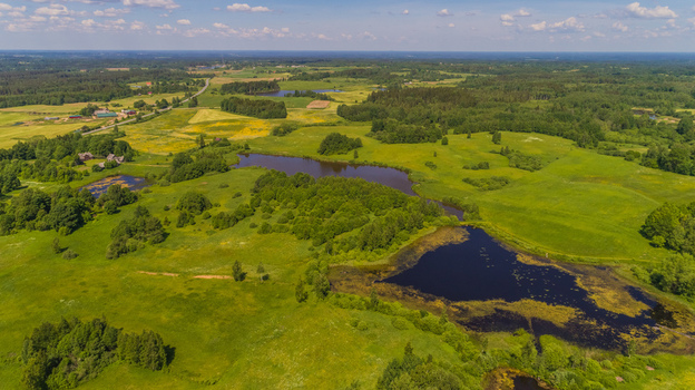 Aerial view of rolling green hills lush forests and small lakes in the countryside of Latvia. Aerial view of rolling green hills lush forests and small lakes in the countryside of Latvia.
