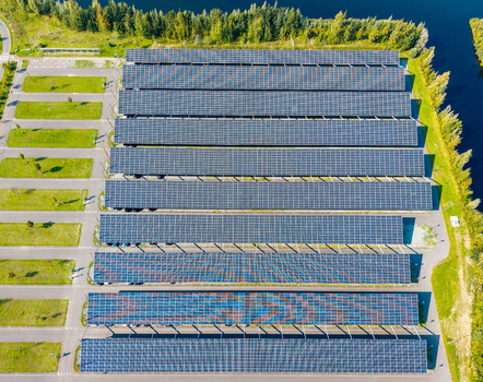 Aerial view of the Zonneweide solar carport featuring rows of photovoltaic panels over a parking area surrounded by green spaces and trees in Harderwijk Gelderland Netherlands.