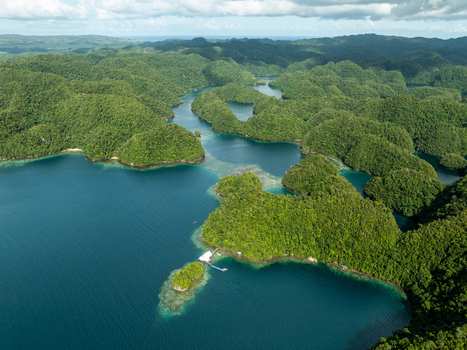 Aerial view of Bucas Grande featuring lush green karst islands surrounded by deep blue and turquoise waters with a small wooden dock in Siargao Philippines. Aerial view of Bucas Grande featuring lush green karst islands surrounded by deep blue and turquoise waters with a small wooden dock in Siargao Philippines.