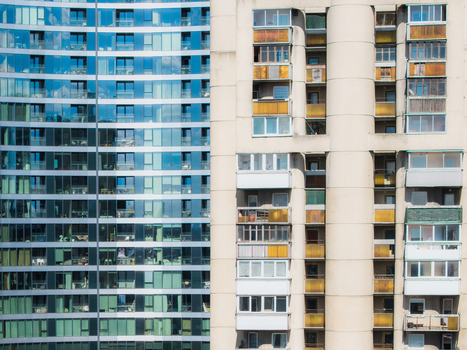 Aerial view of a modern glass skyscraper juxtaposed with a traditional Soviet era concrete apartment building with balconies in Vilnius Vilniaus apskritis Lithuania. Aerial view of a modern glass skyscraper juxtaposed with a traditional Soviet era concrete apartment building with balconies in Vilnius Vilniaus apskritis Lithuania.