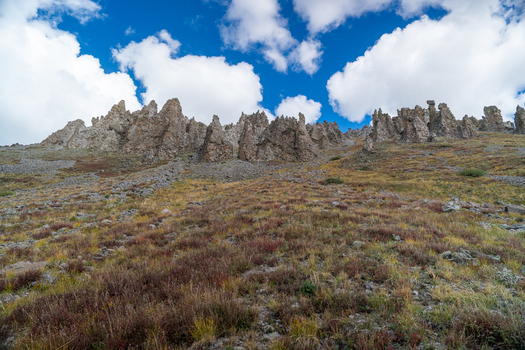 View of the rugged rocky peaks and alpine tundra of San Luis Peak under a bright blue sky with scattered clouds in Creede Colorado United States. View of the rugged rocky peaks and alpine tundra of San Luis Peak under a bright blue sky with scattered clouds in Creede Colorado United States.
