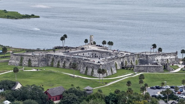 Aerial view of Castillo de San Marcos National Monument with historic stone walls grassy moat and palm trees along the Matanzas River in St. Augustine Florida United States. Aerial view of Castillo de San Marcos National Monument with historic stone walls grassy moat and palm trees along the Matanzas River in St. Augustine Florida United States.