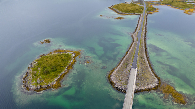 Aerial view of the bridge connecting islands in the Lofoten archipelago surrounded by turquoise waters and rocky islets Nordland Norway.