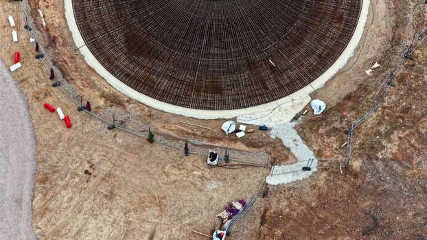 Aerial view of a circular wind turbine foundation under construction with steel rebar reinforcement and concrete base in Latvija. Aerial view of a circular wind turbine foundation under construction with steel rebar reinforcement and concrete base in Latvija.