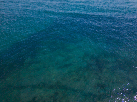 Aerial view of the clear blue waters of the English Channel near the historic harbour of Charlestown Cornwall United Kingdom. Aerial view of the clear blue waters of the English Channel near the historic harbour of Charlestown Cornwall United Kingdom.
