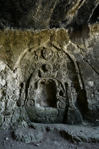 View of an ancient stone relief carving featuring intricate symbols and weathered textures inside a cave in Mallorca Balearic Islands Spain.