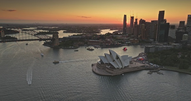 Aerial view of Sydney Opera House and Sydney Harbour Bridge at sunset with city skyline and calm water in Sydney New South Wales Australia. Aerial view of Sydney Opera House and Sydney Harbour Bridge at sunset with city skyline and calm water in Sydney New South Wales Australia.